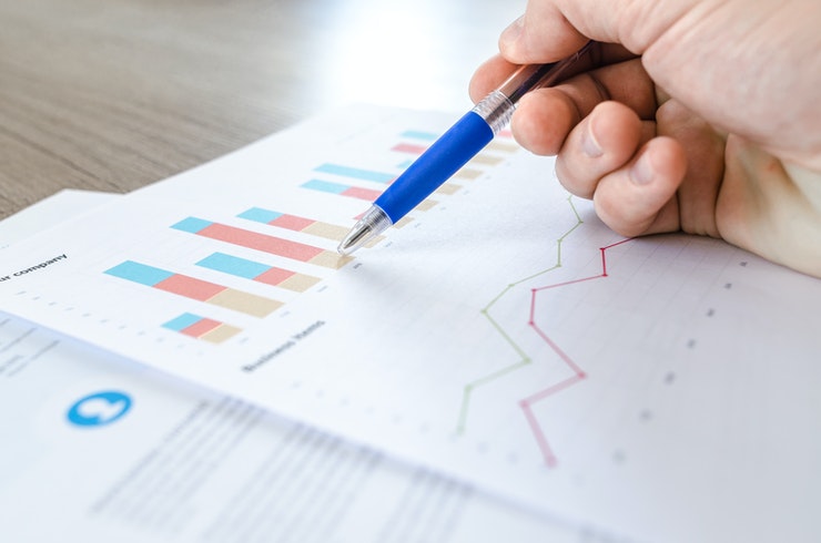 white hand pointing a chart with pen.