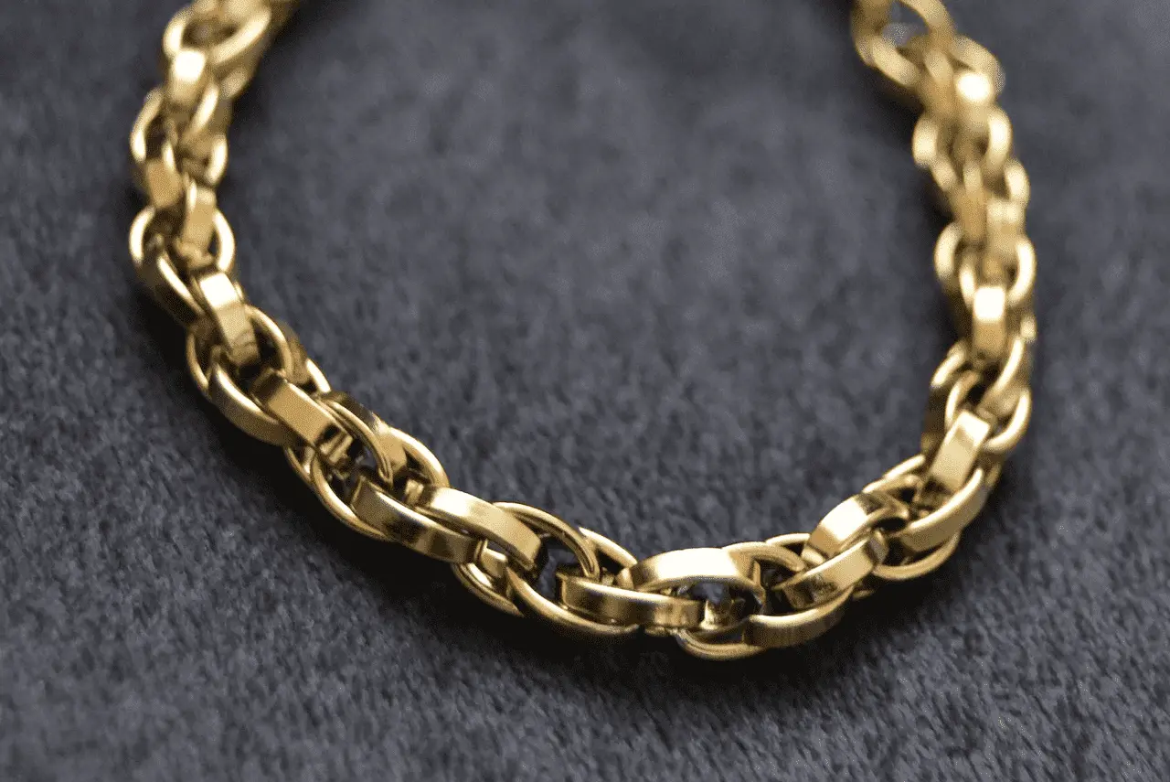 Close up image of gold chain links on top of gray material.